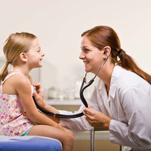 Woman checking the heartbeat of a child patient